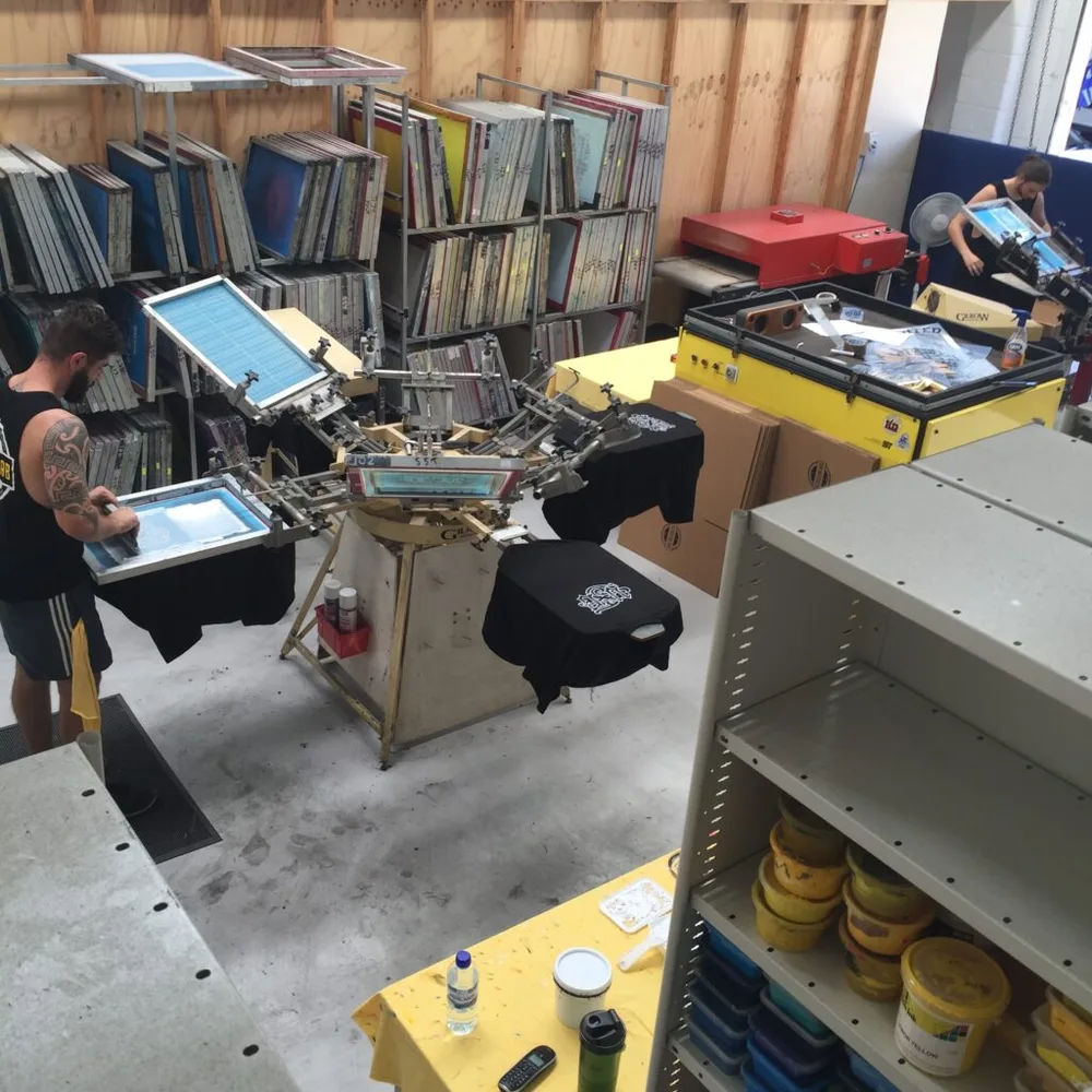 Screenlab's screen printing floor at capacity, with racked screens and a carousel in use